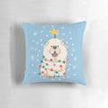 Fluffy white chow chow dog sitting on a Christmas tree-shaped pillow