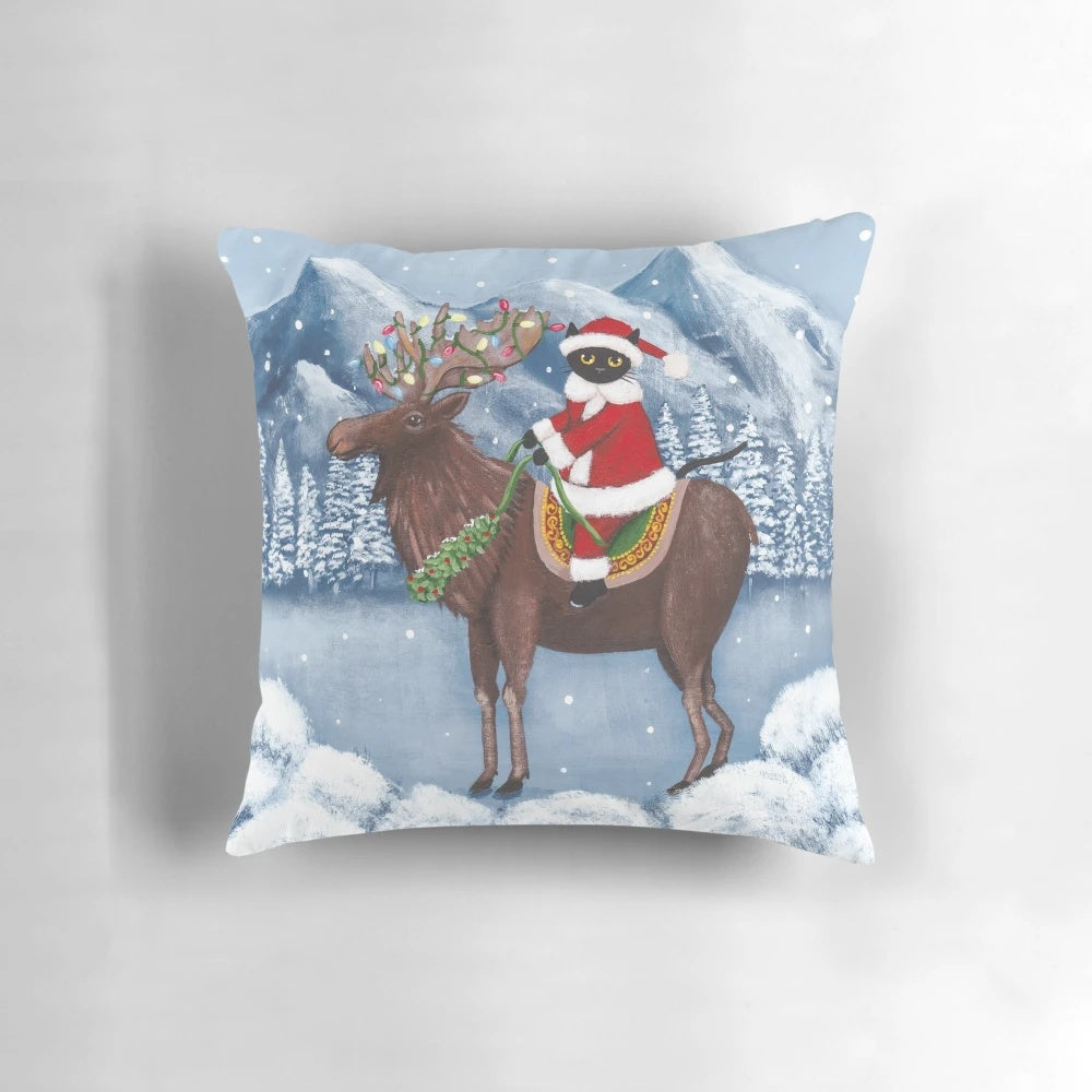 A cozy and whimsical Christmas pillow featuring a black cat and a moose in a festive holiday scene.