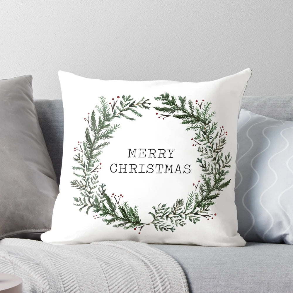 A simple, merry Christmas-themed throw pillow with a watercolor wreath design on a green background.