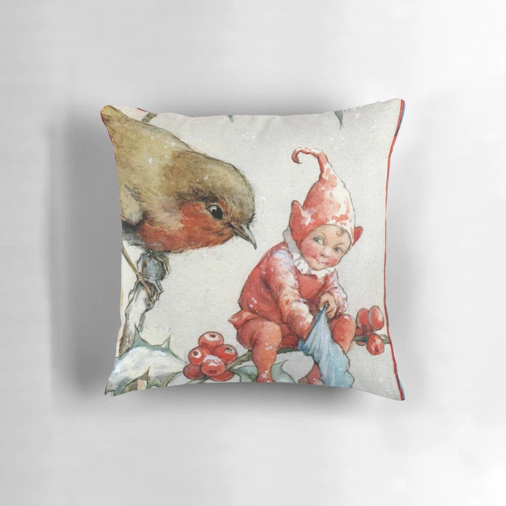 Decorative holiday pillow featuring a charming illustration of a Christmas robin and elf in a snowy woodland scene by artist Margaret Tarrant.