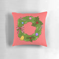 A cozy Christmas wreath pillow with green, red, bells, and candy decorations.