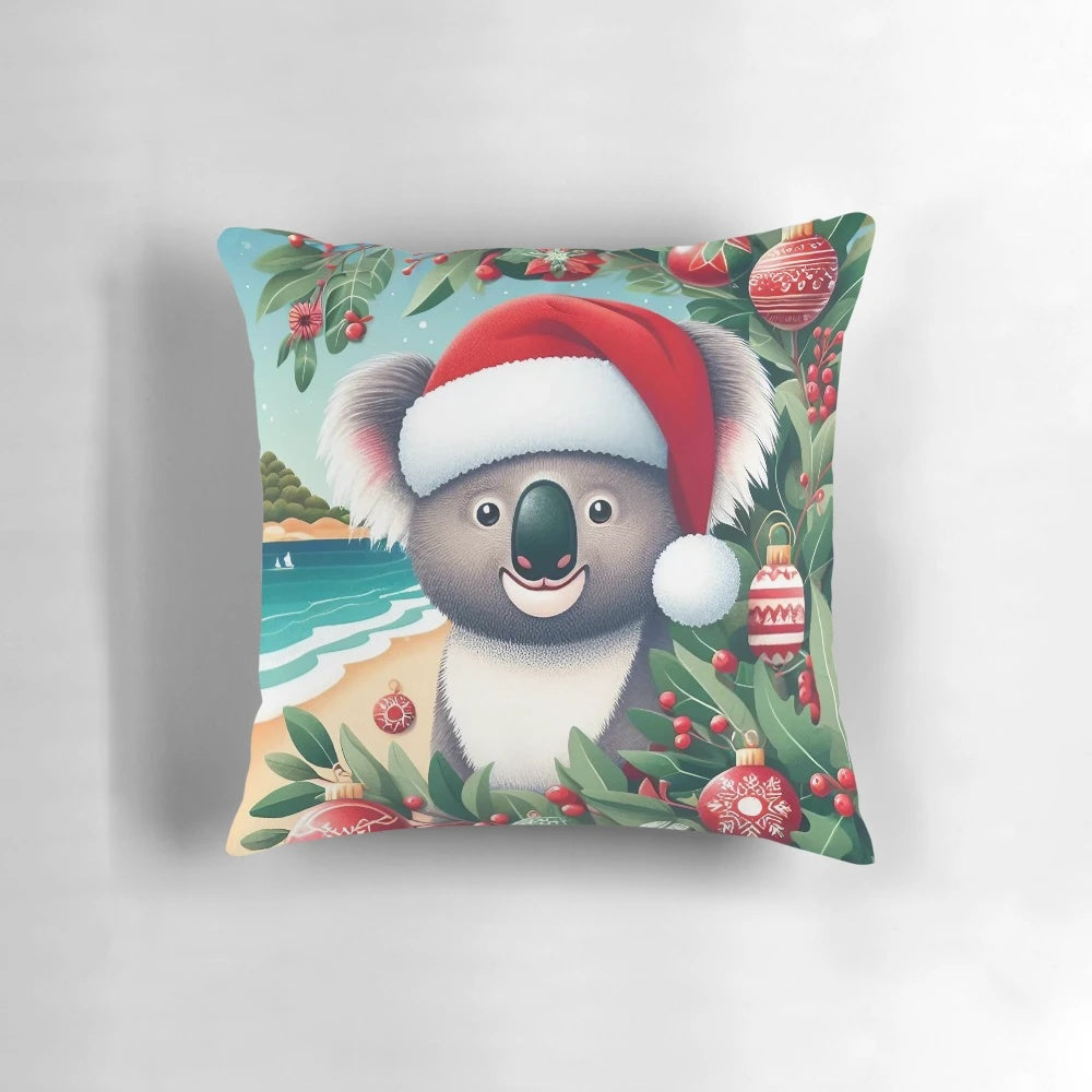 Cute Aussie koala wearing a Santa hat on a Christmas-themed pillow with eucalyptus leaves and a beach backdrop.