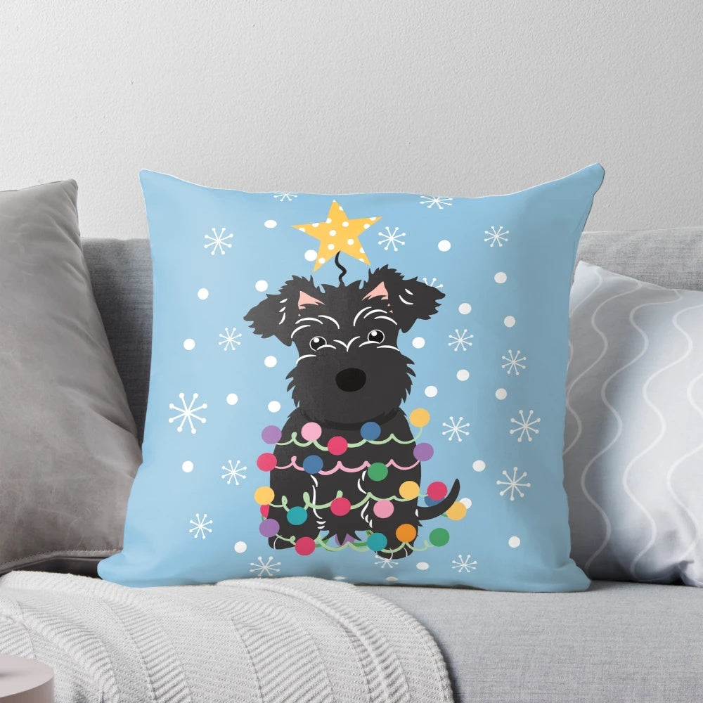 A fluffy black miniature schnauzer dog sitting on a Christmas tree-shaped pillow.