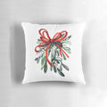 A decorative pillow featuring a branch of green mistletoe with white berries, a classic symbol of the holiday season.