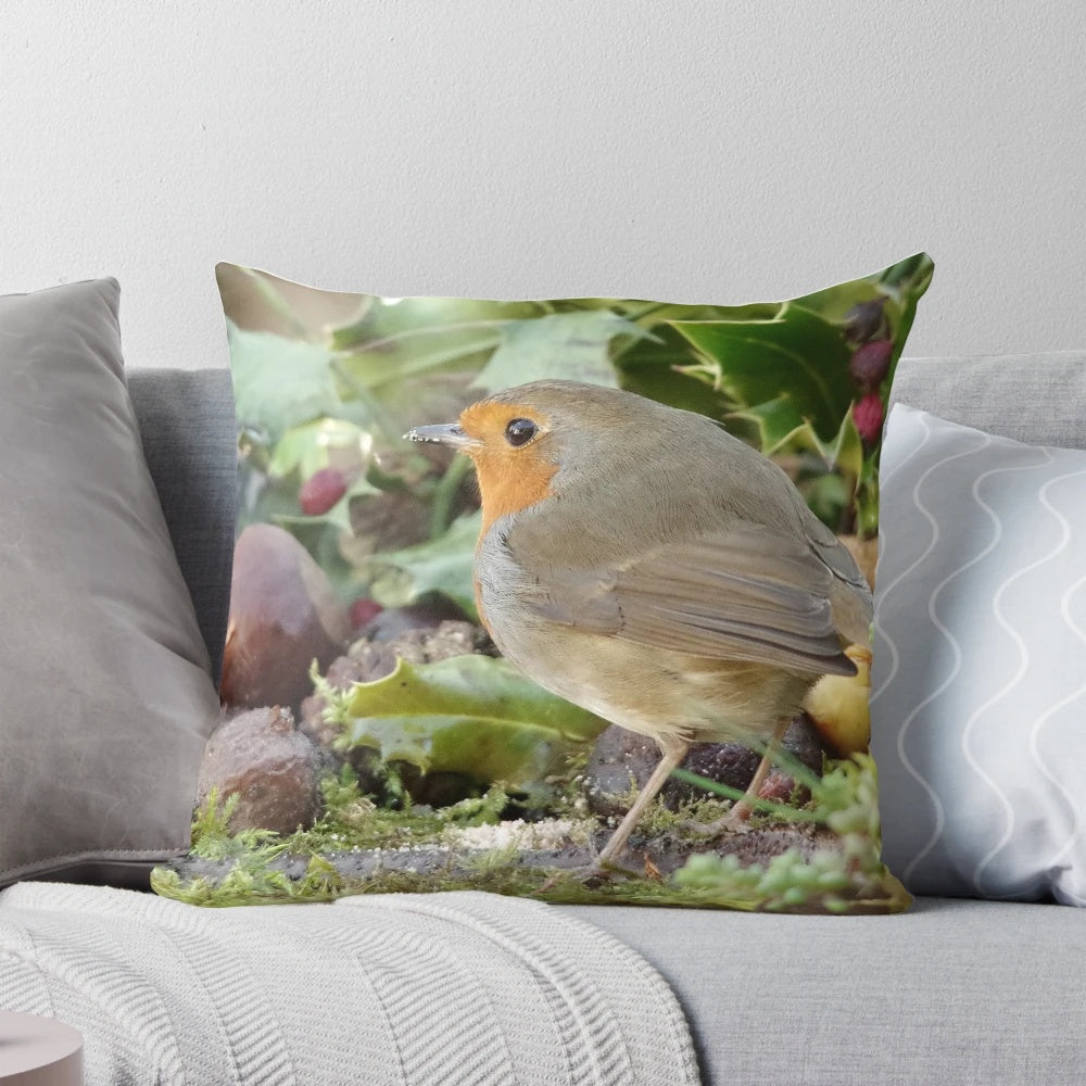 Decorative holiday pillow featuring a robin perched on holly branches