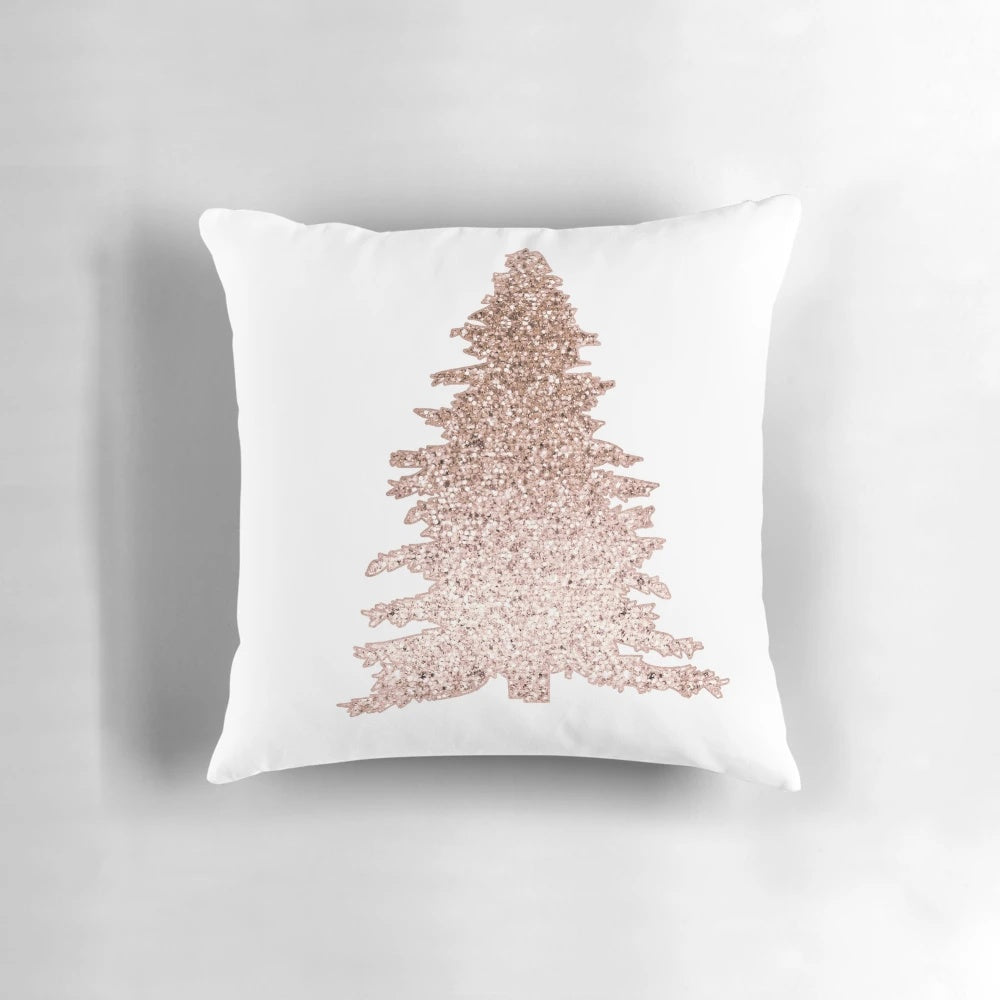 A decorative throw pillow featuring a sparkling rose gold Christmas tree with abstract leaves and holiday accents.