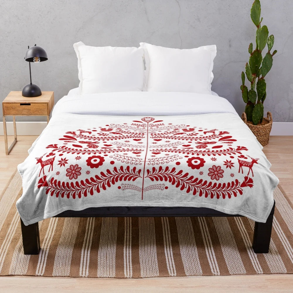 Red plush blanket featuring a whimsical Scandinavian-style Christmas tree design
