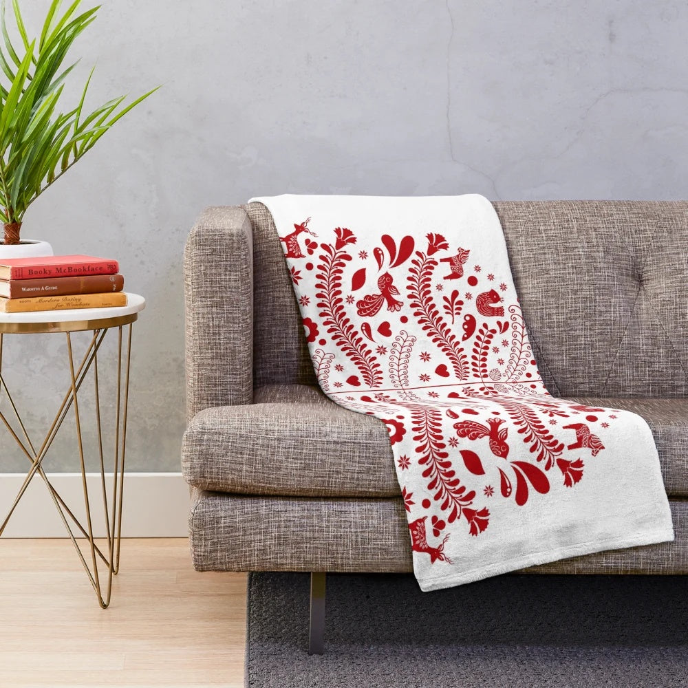 Red plush blanket featuring a whimsical Scandinavian-style Christmas tree design