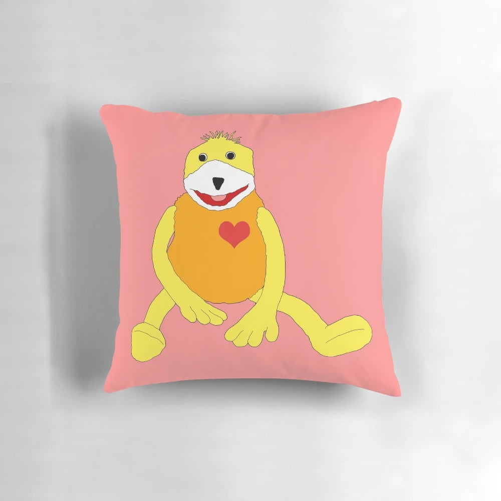 Flat Eric, a cute yellow puppet, printed on a soft, pink heart-shaped pillow with a sweet smile.