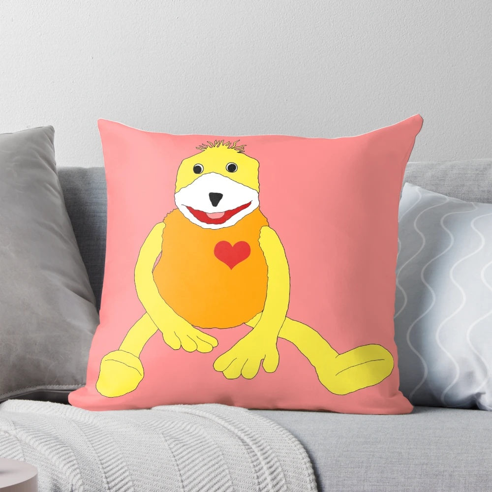 Flat Eric, a cute yellow puppet, printed on a soft, pink heart-shaped pillow with a sweet smile.