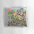 Colorful floral pillow featuring a 3D collage of wildflowers and a garden scene