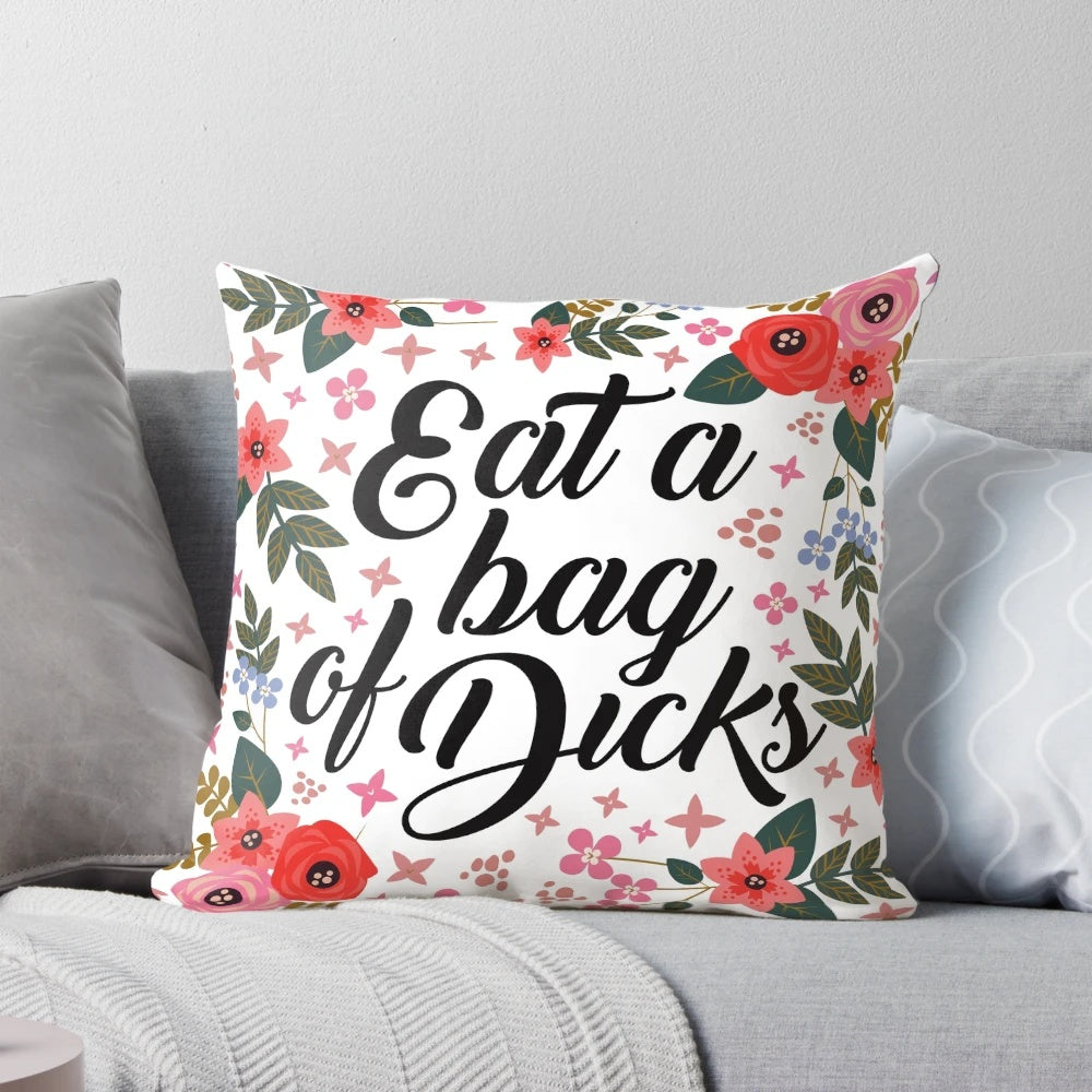 Floral decorative pillow with the text "Eat a Bag of Dicks" in a bold, cursive font