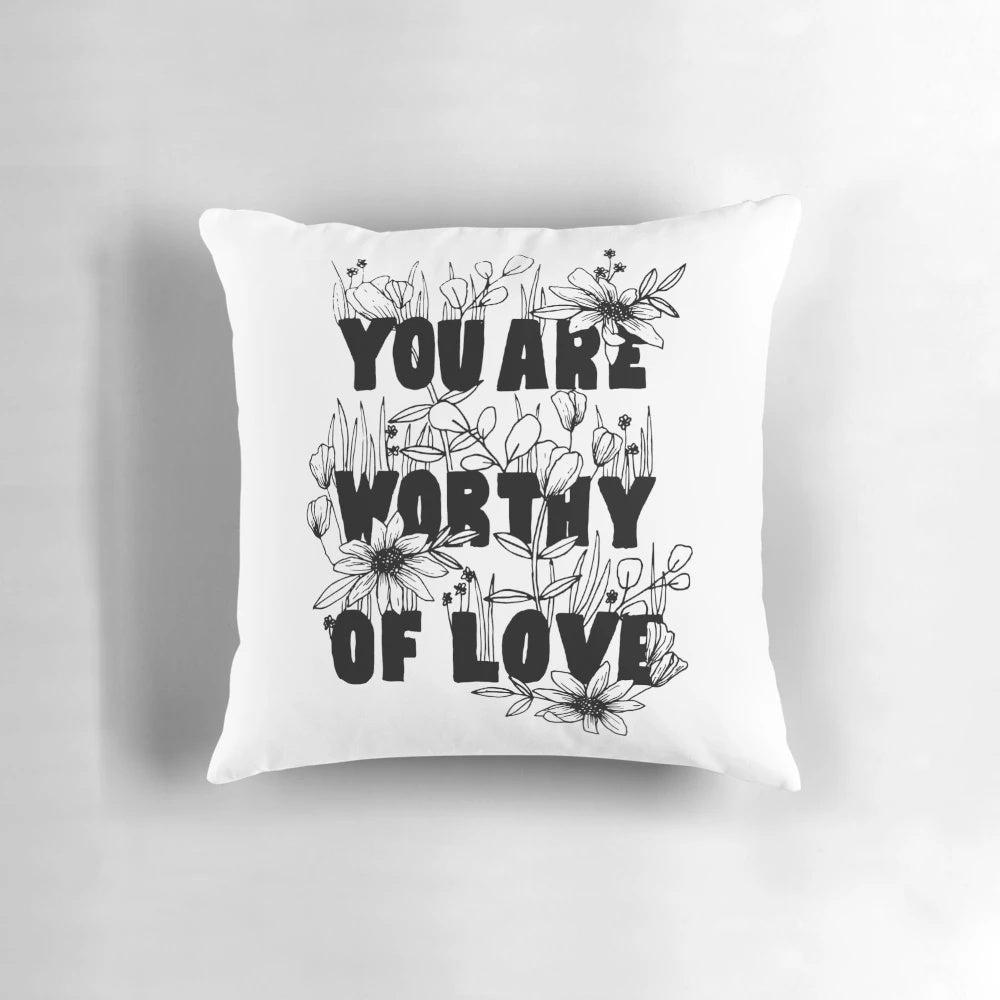 Floral-patterned decorative pillow with the text "You Are Worthy of Love