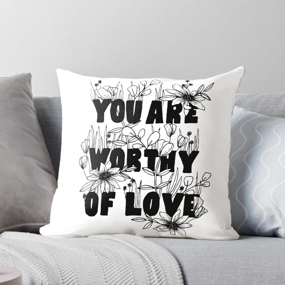 Floral-patterned decorative pillow with the text "You Are Worthy of Love