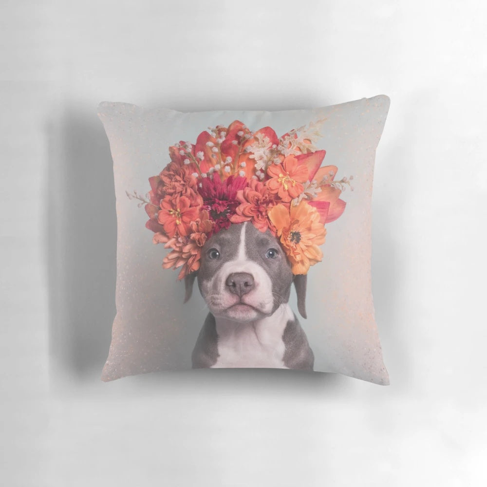 A colorful throw pillow featuring a pit bull or staffordshire terrier dog wearing a flower crown, inspired by the work of photographer Sophie Gamand.