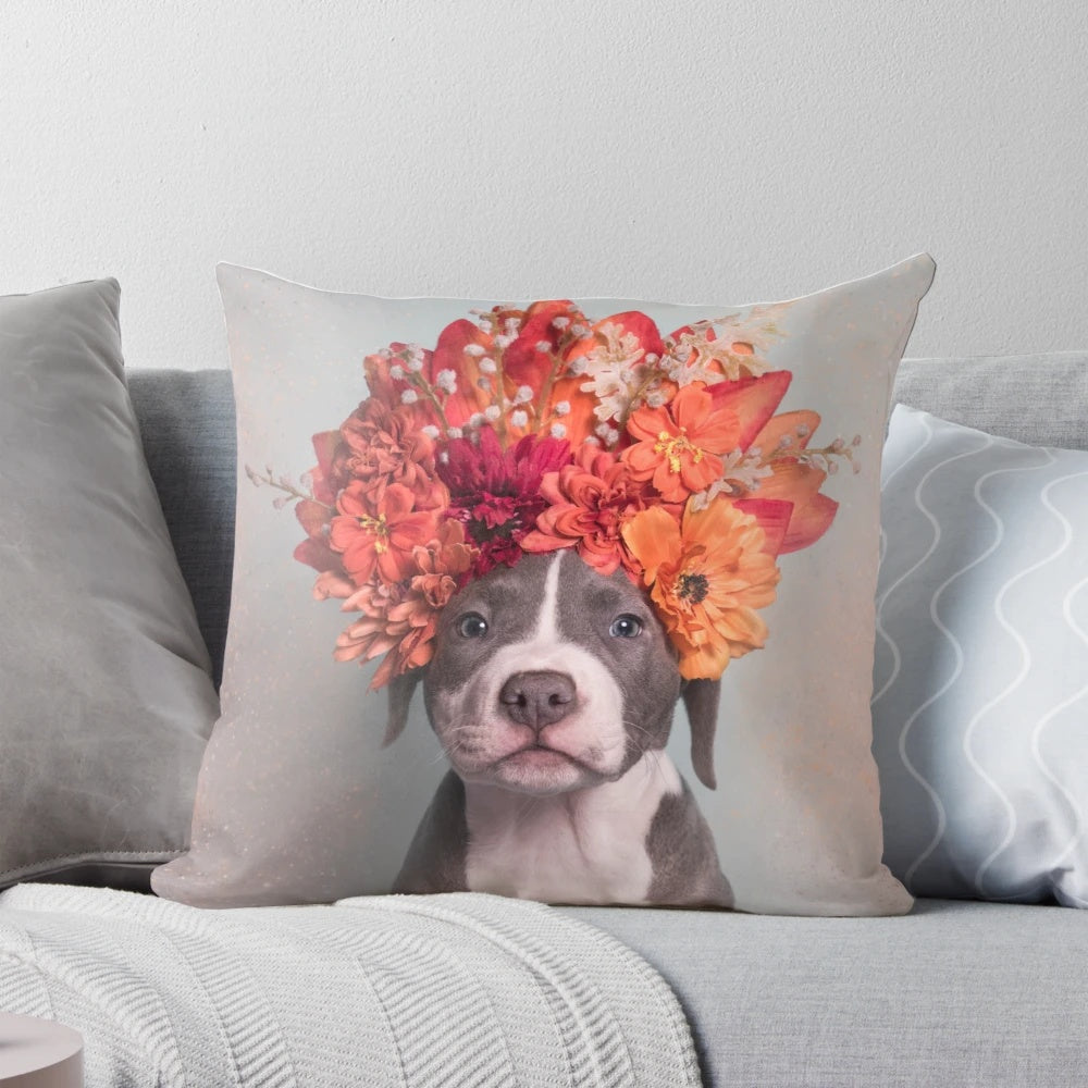 A colorful throw pillow featuring a pit bull or staffordshire terrier dog wearing a flower crown, inspired by the work of photographer Sophie Gamand.