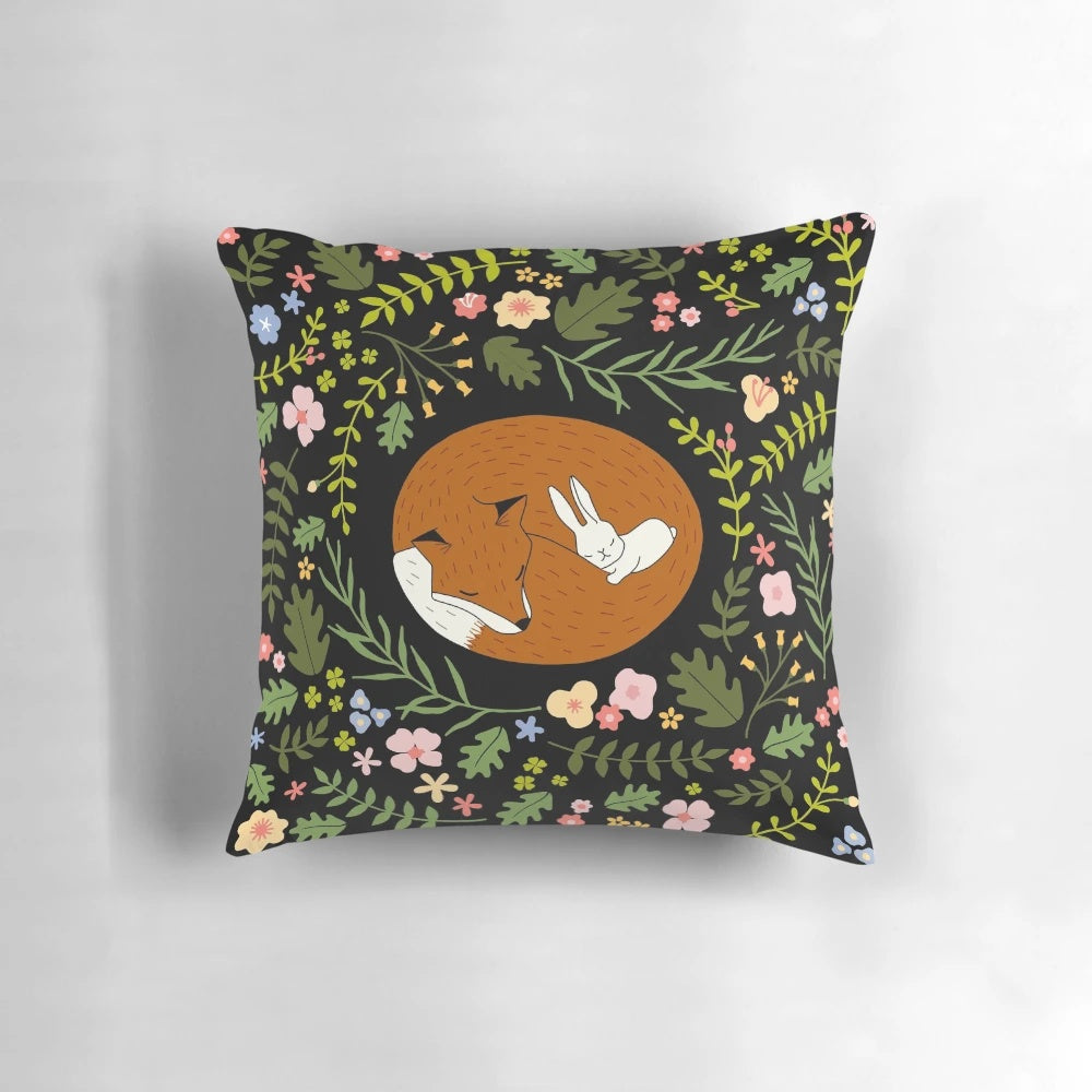 Decorative pillow featuring a whimsical print of a fox and rabbit in a floral and leaf pattern, perfect for animal lovers and friends.