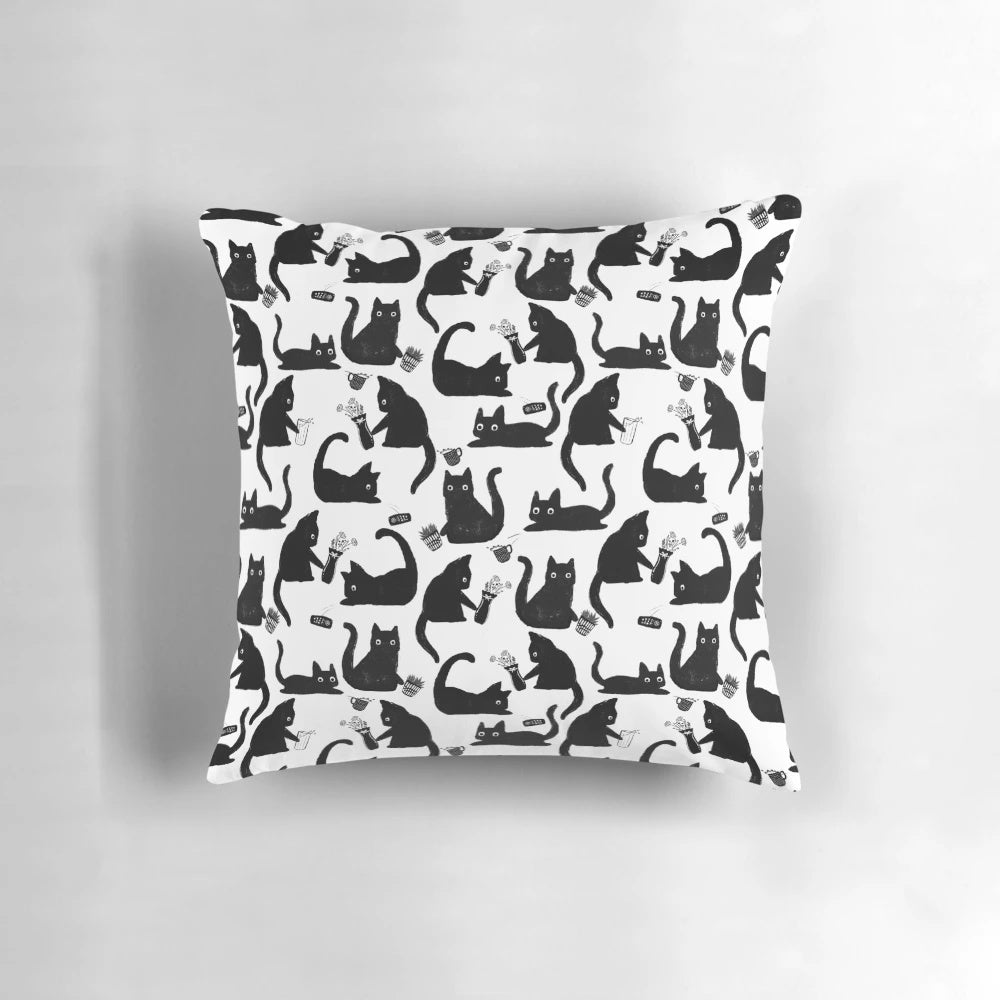 Throw pillow with a hand-drawn pattern of black and white cats knocking things over, a humorous design for cat lovers.