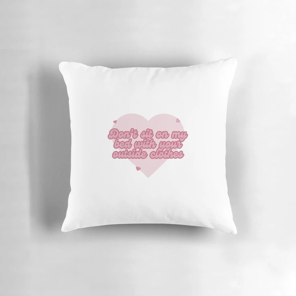 A plush, customizable pillow that reads "Don't sit on my bed with your outside clothes" in a playful, relatable design.