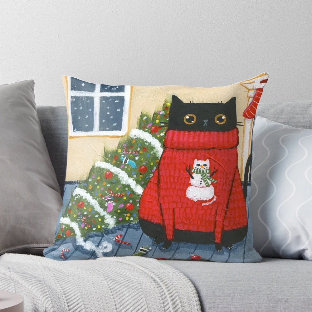 A black cat with an "It Wasn't Me" expression knocks over a Christmas tree on a plush pillow