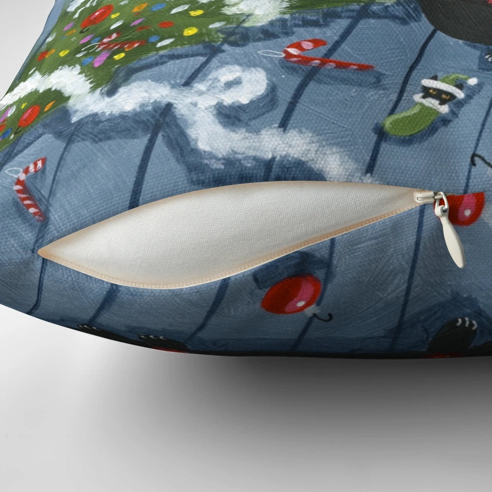 A black cat with an "It Wasn't Me" expression knocks over a Christmas tree on a plush pillow