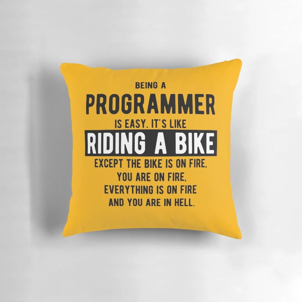 Light color pillow with a funny programming joke - "Being a programmer is easy. It's like riding a bike.