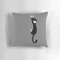 A black and white tuxedo cat hanging on to a pillow with a cartoon illustration design