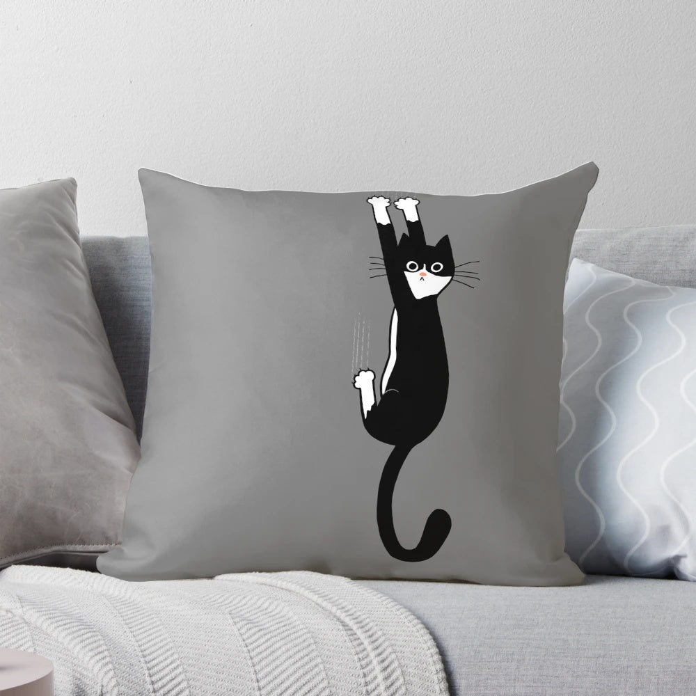 A black and white tuxedo cat hanging on to a pillow with a cartoon illustration design