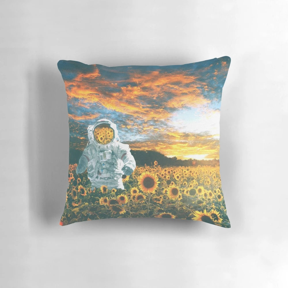 A whimsical pillow featuring a spaceman surrounded by sunflowers, set against a starry night sky.