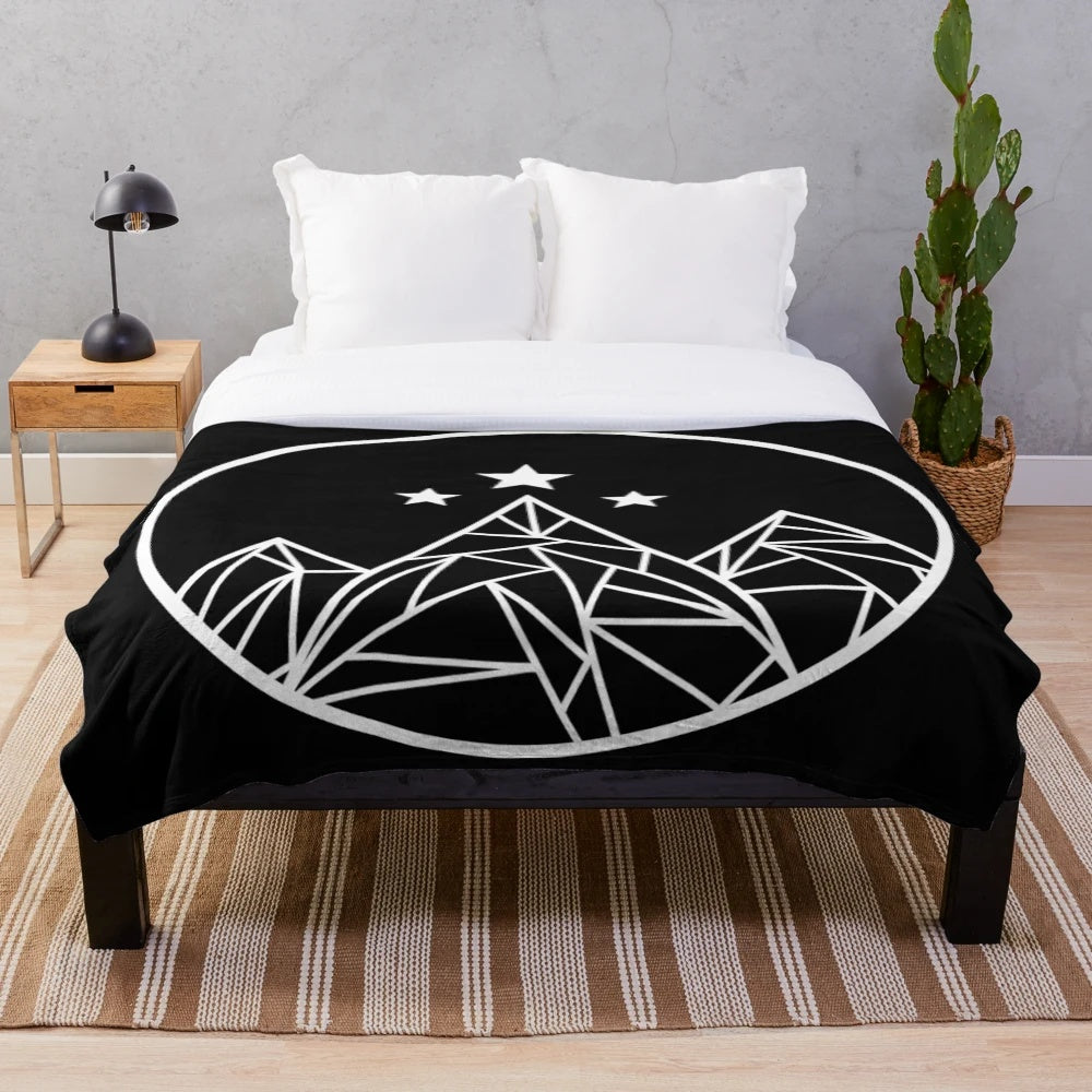 Plush blanket featuring a white outline design of mountains and stars against a galaxy background