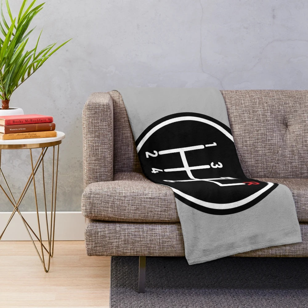 Plush blanket featuring a red manual transmission logo