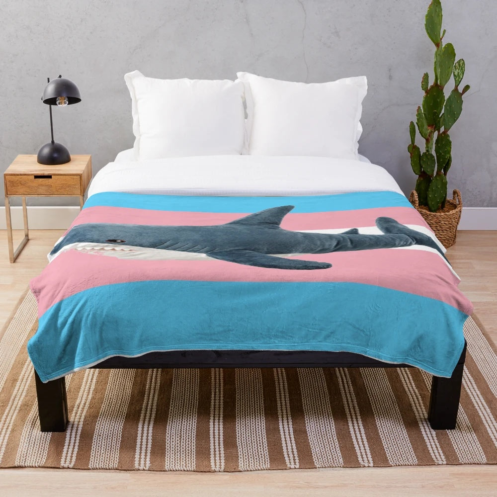 Cozy plush blanket featuring a trans pride design on a shark character