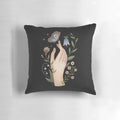 A close-up of a hand-painted nature and floral design with a butterfly on a black pillow.
