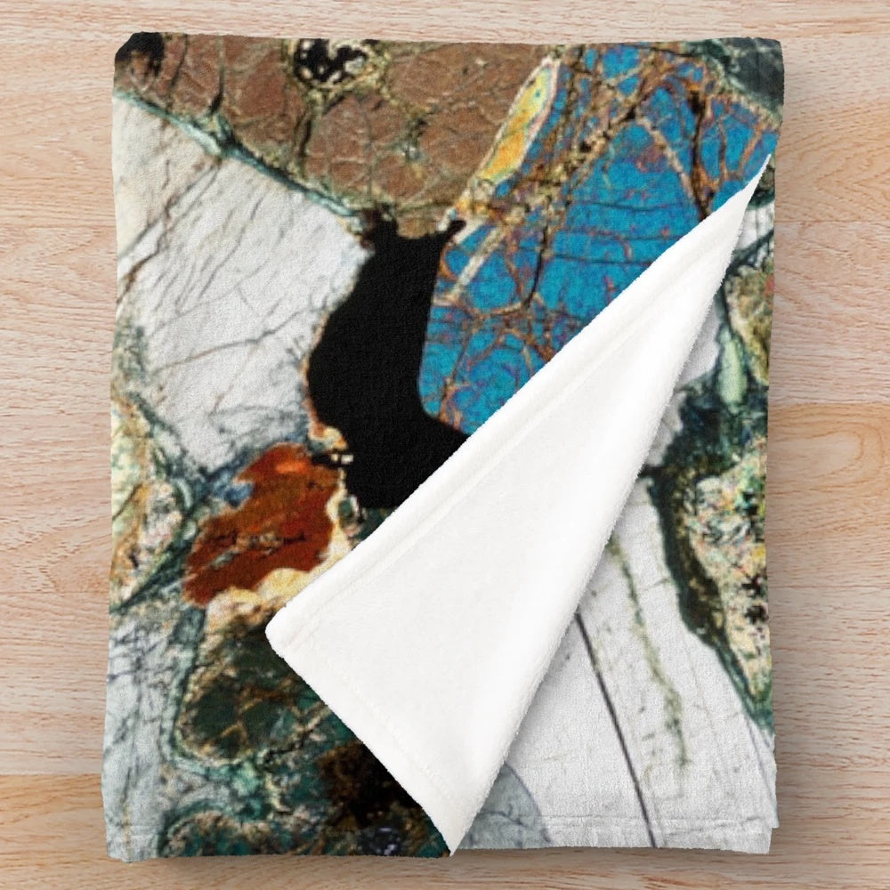 Plush blanket featuring a microscope photo of peridotite rock from Scotland