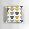 A geometric pattern pillow in shades of mustard yellow, gray, and blue