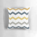 A decorative throw pillow featuring a minimalist honeycomb chevron pattern in shades of mustard yellow, dark blue, grey, and white.