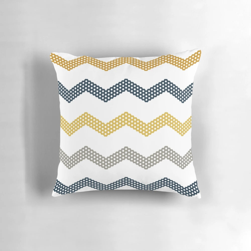 A decorative throw pillow featuring a minimalist honeycomb chevron pattern in shades of mustard yellow, dark blue, grey, and white.