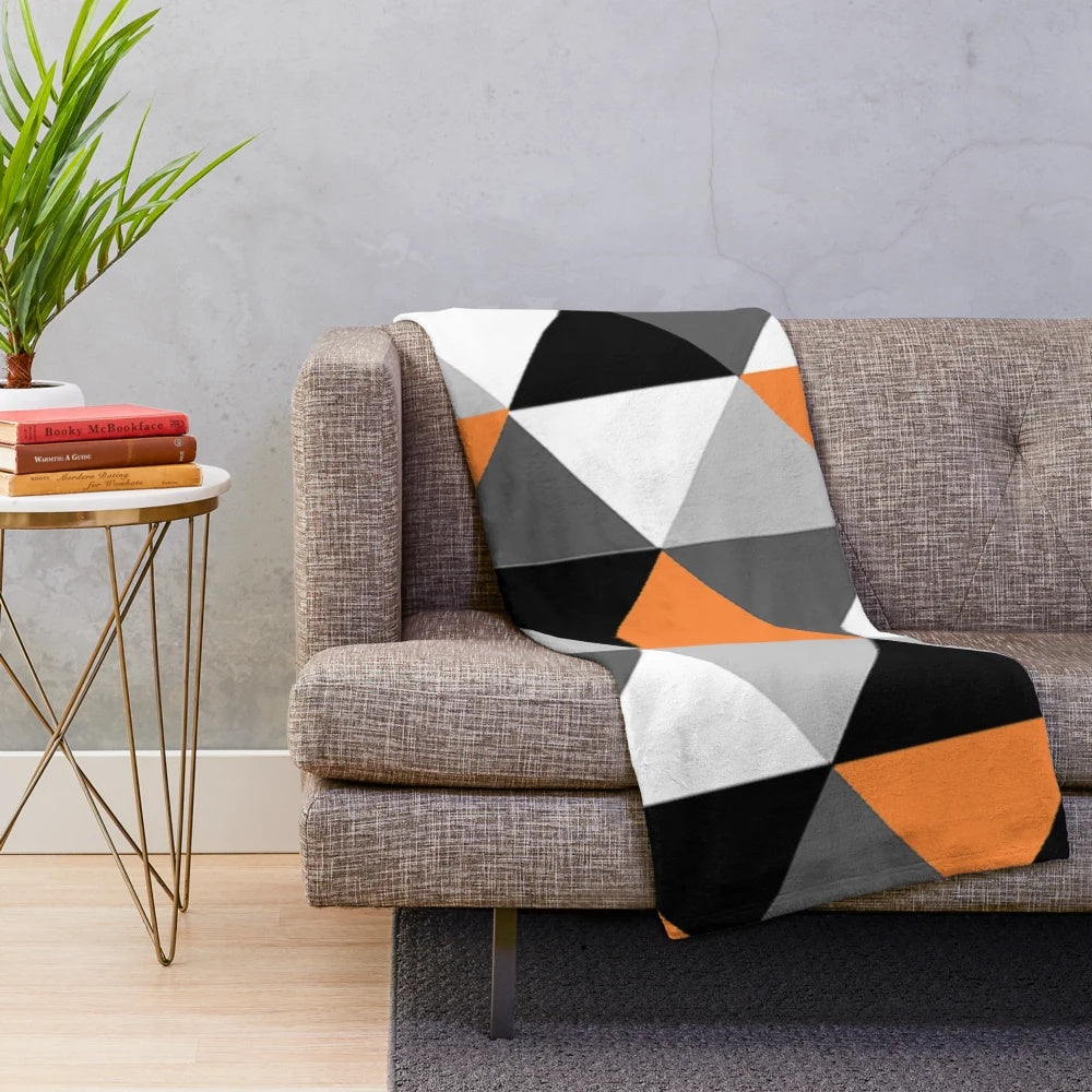 Geometric pattern plush blanket in orange, black, white, and grey colors