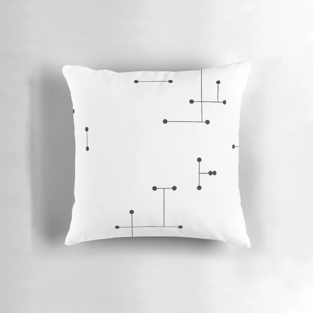 A modern, minimalist pillow featuring a geometric pattern of black and white dots, inspired by the iconic Eames design.