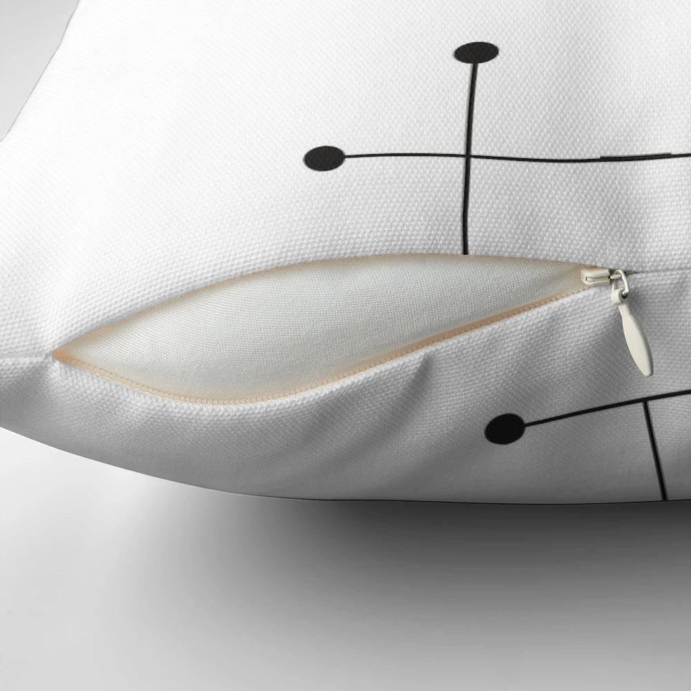A modern, minimalist pillow featuring a geometric pattern of black and white dots, inspired by the iconic Eames design.