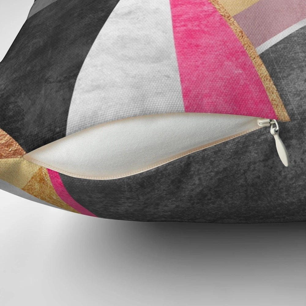A soft, square pillow with a vibrant, geometric pink and white abstract pattern design.