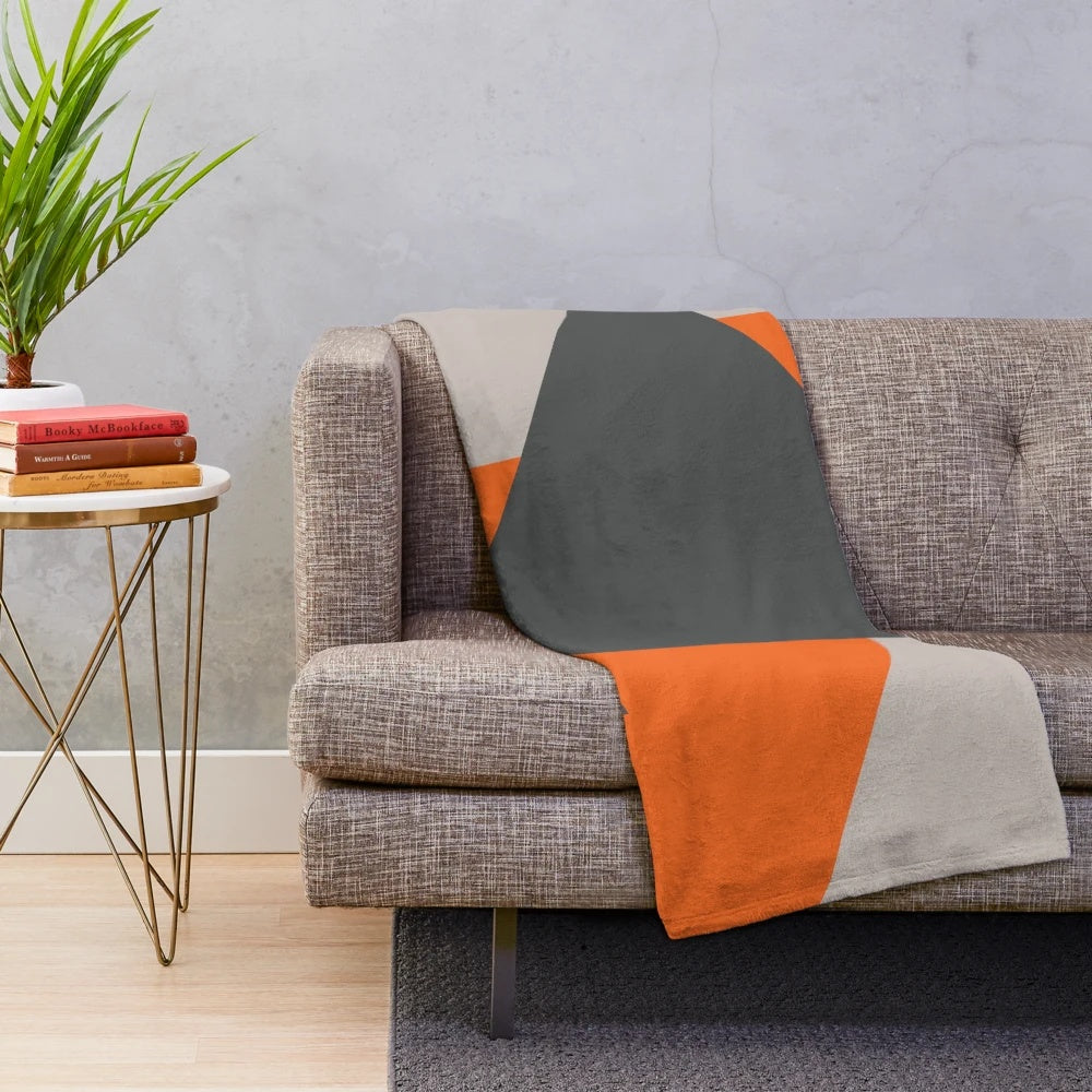 Cozy plush blanket featuring a geometric triangle pattern in orange and grey