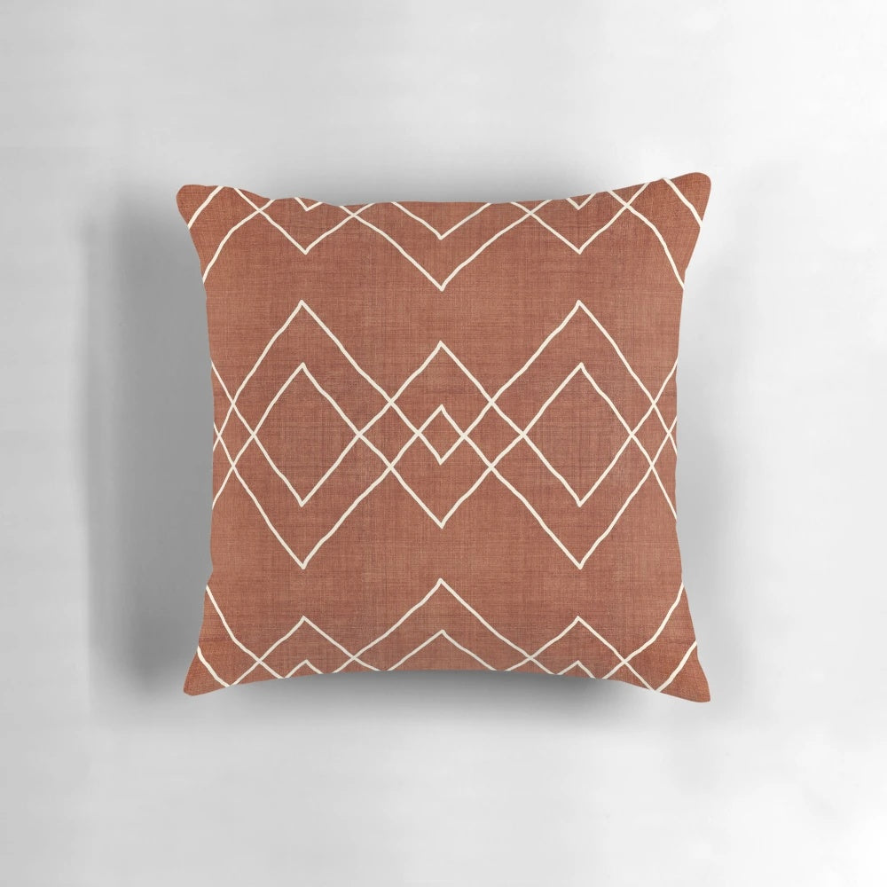 Nudo in Rust Pillow - a geometric, boho-inspired accent pillow with a rust, red, and white color scheme