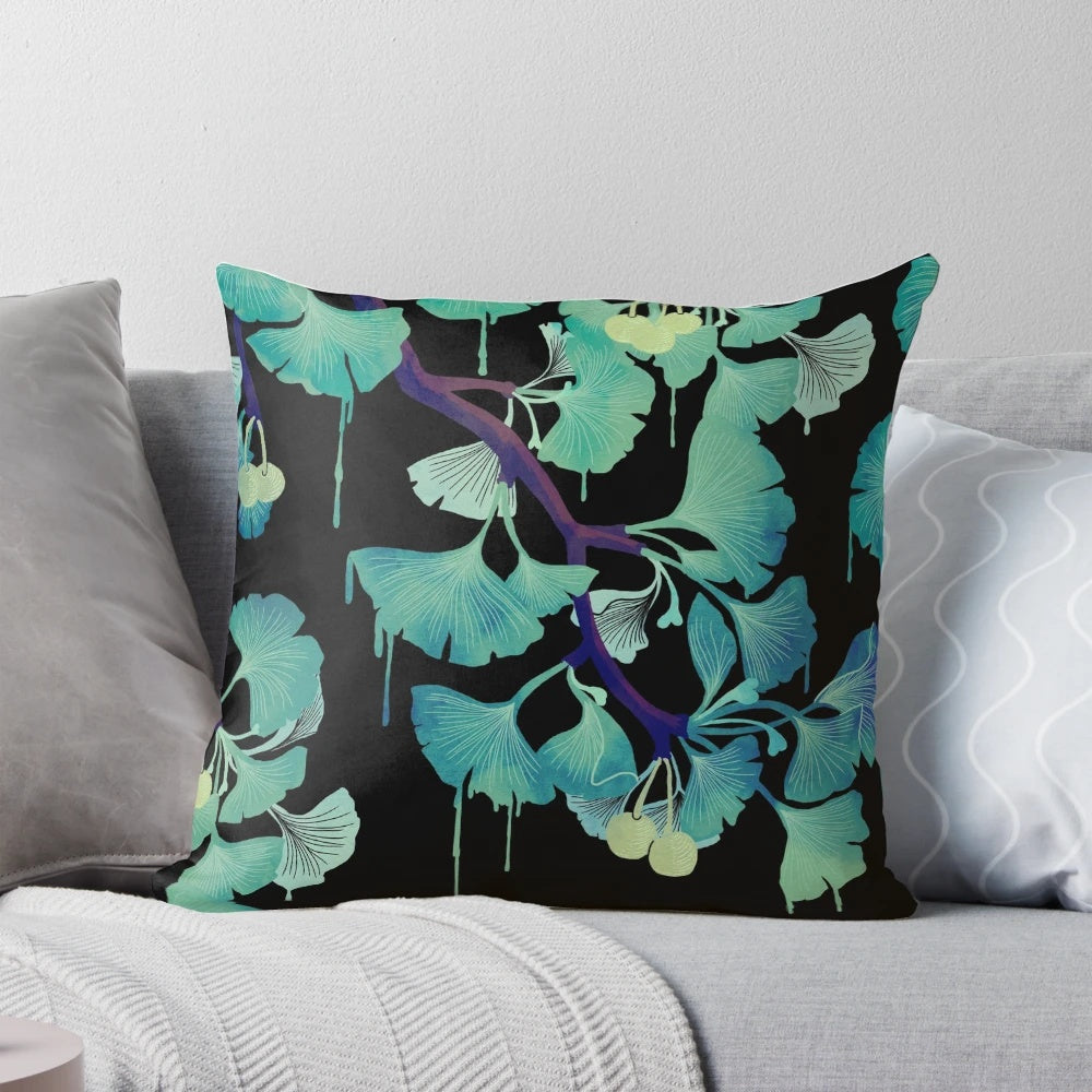 Artistic watercolor painting of ginkgo leaves on a black background, printed on a decorative throw pillow.