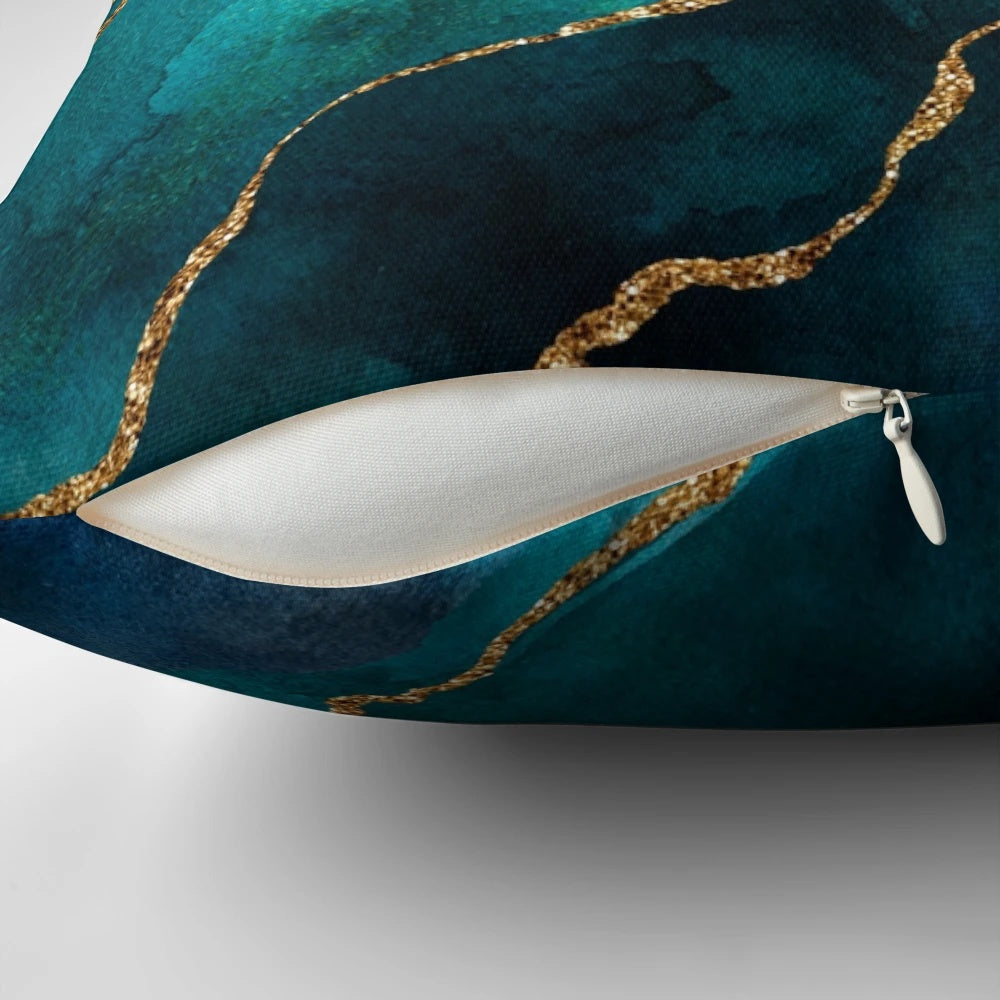 A decorative pillow featuring a golden and teal watercolor design with gemstones and minerals.