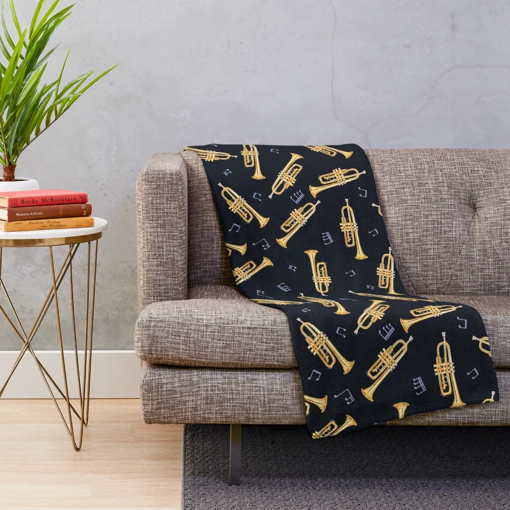 Gold trumpet design on a plush blanket for music lovers