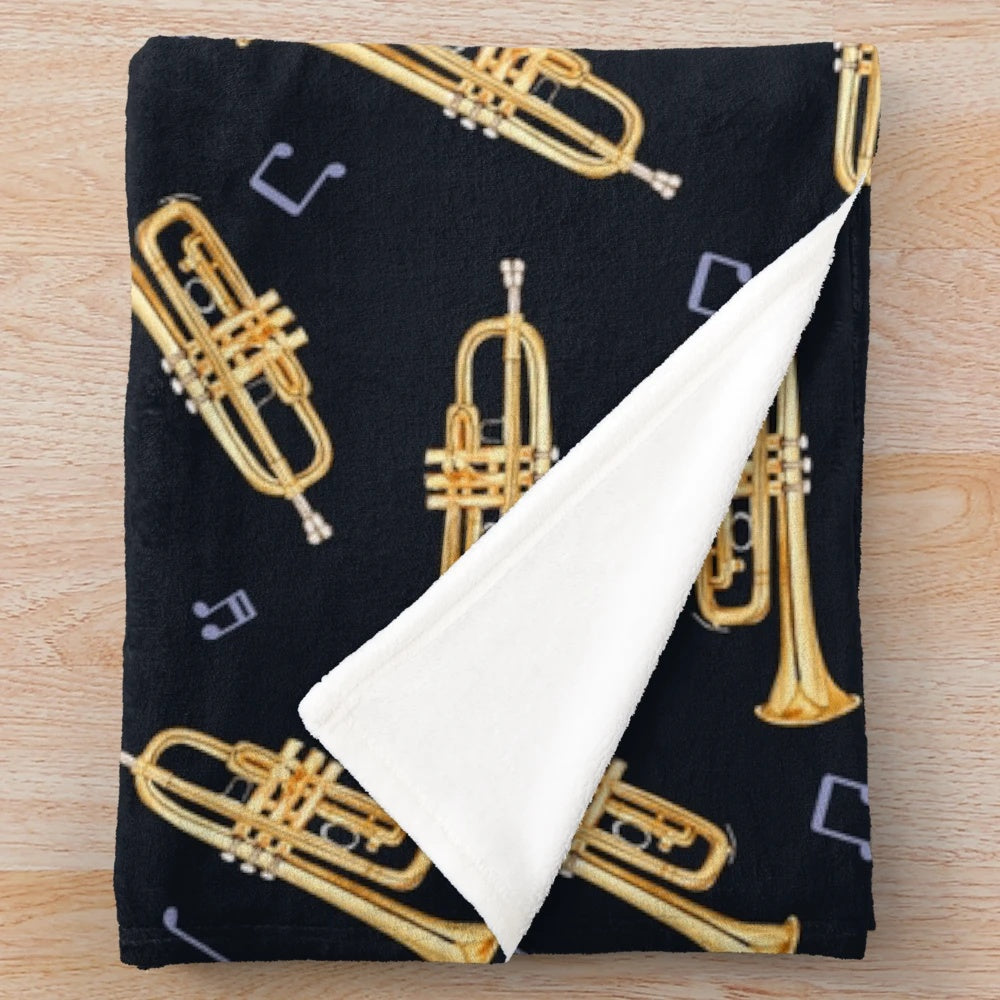 Gold trumpet design on a plush blanket for music lovers