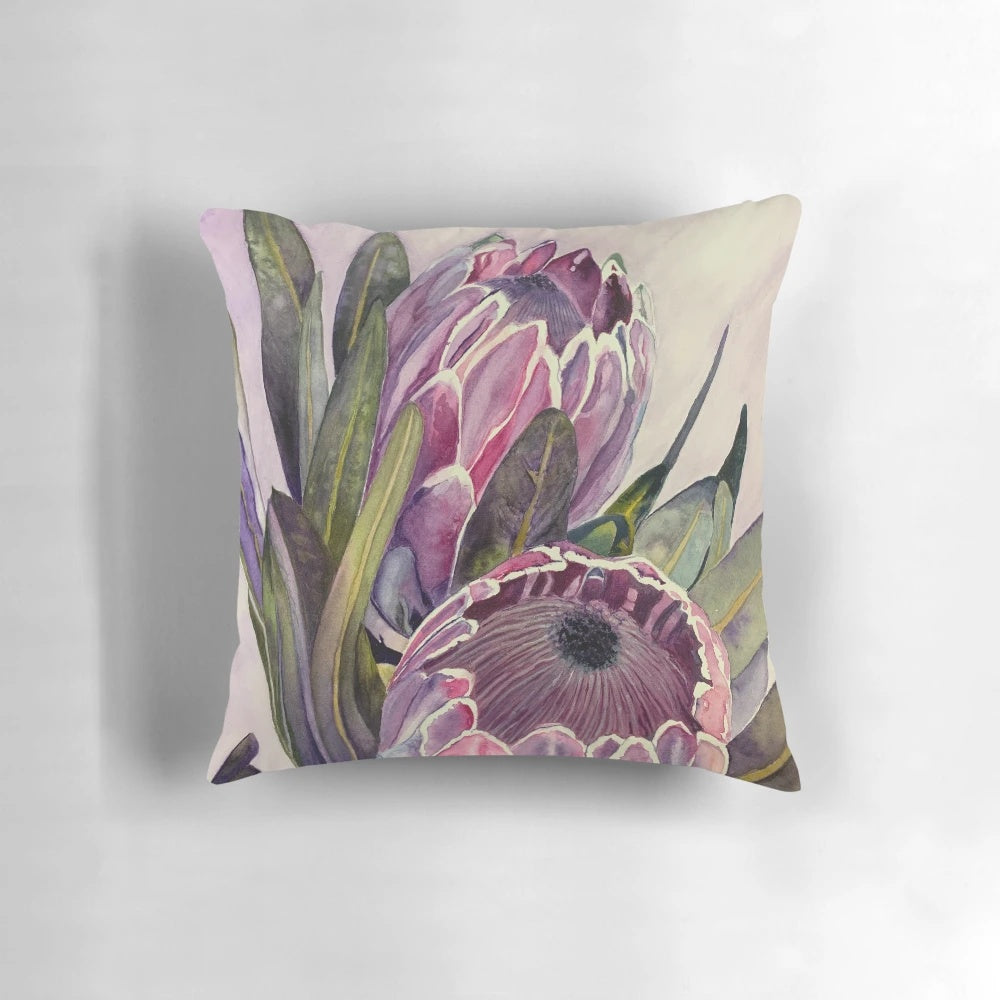 Vibrant watercolor painting of a protea flower showcased on a decorative throw pillow.