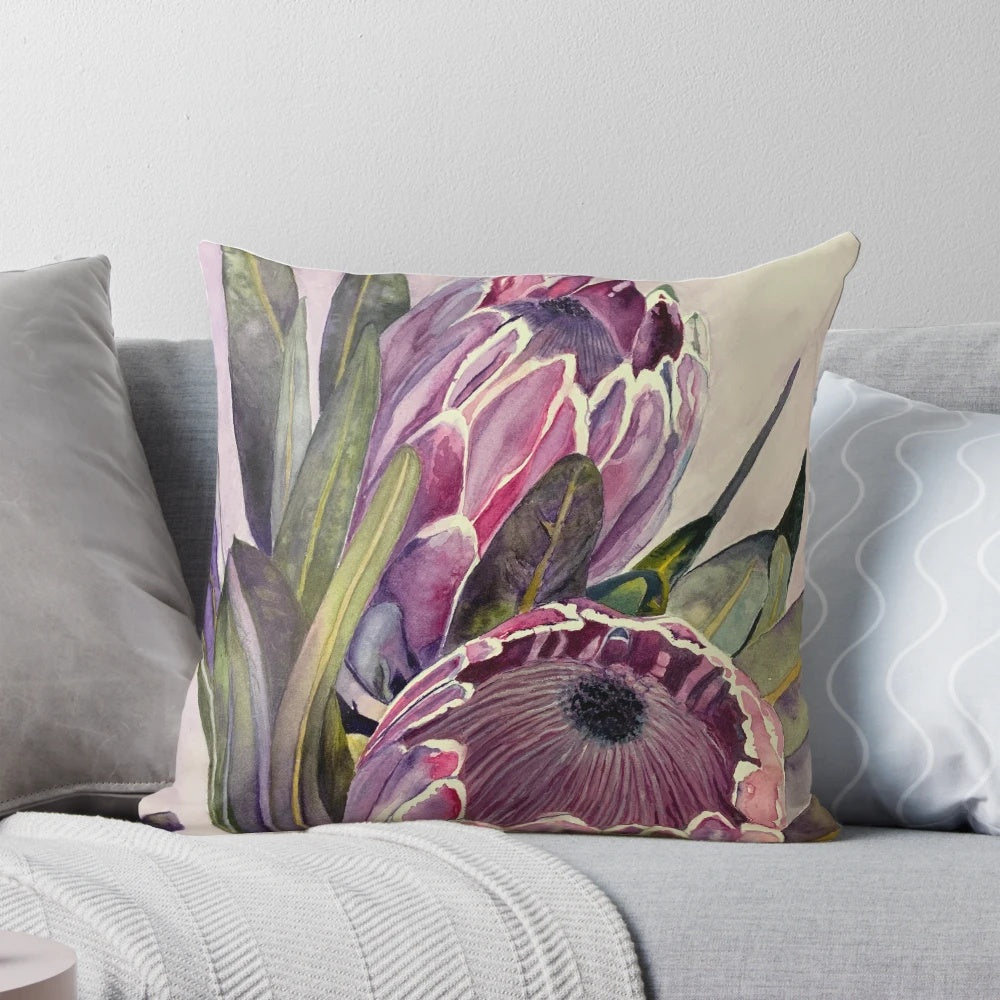 Vibrant watercolor painting of a protea flower showcased on a decorative throw pillow.