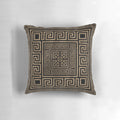 Decorative throw pillow featuring a Greek key ornament and meander pattern in gold on a black background.